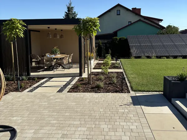 Założony ogród z pergolą, kostką brukową i trawnikiem – realizacja Komfortowe Ogrody