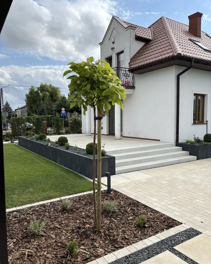 Front domu z nawierzchnią i rabatami – po realizacji